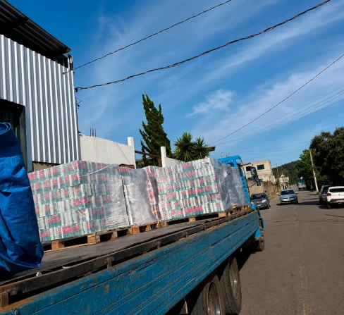 Caminhão de carroceria carregado com pallets saindo para rota interestadual a partir da região de BH